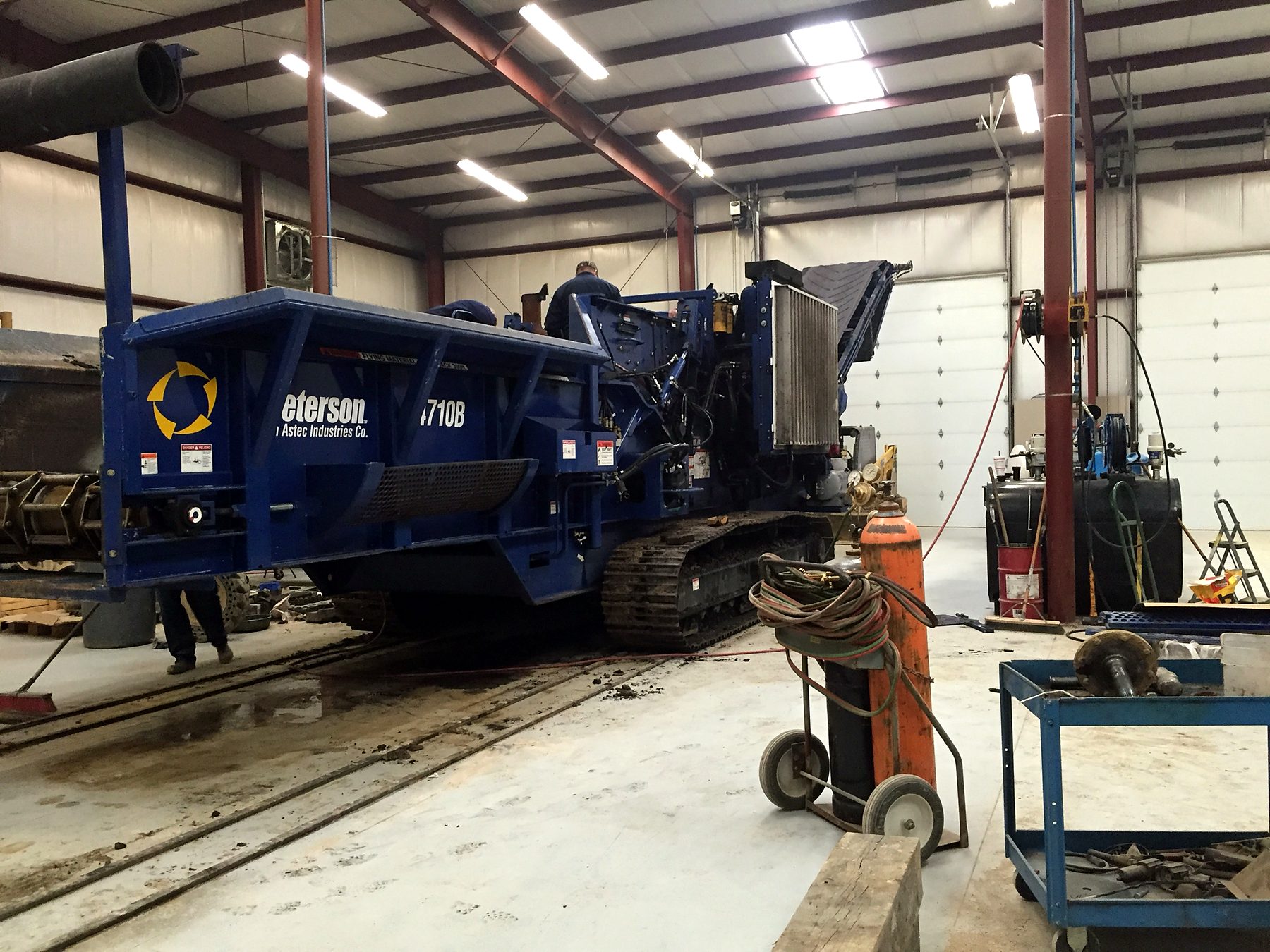 A-1 mechanics servicing a shingle grinder inside the shop on Bishop Road