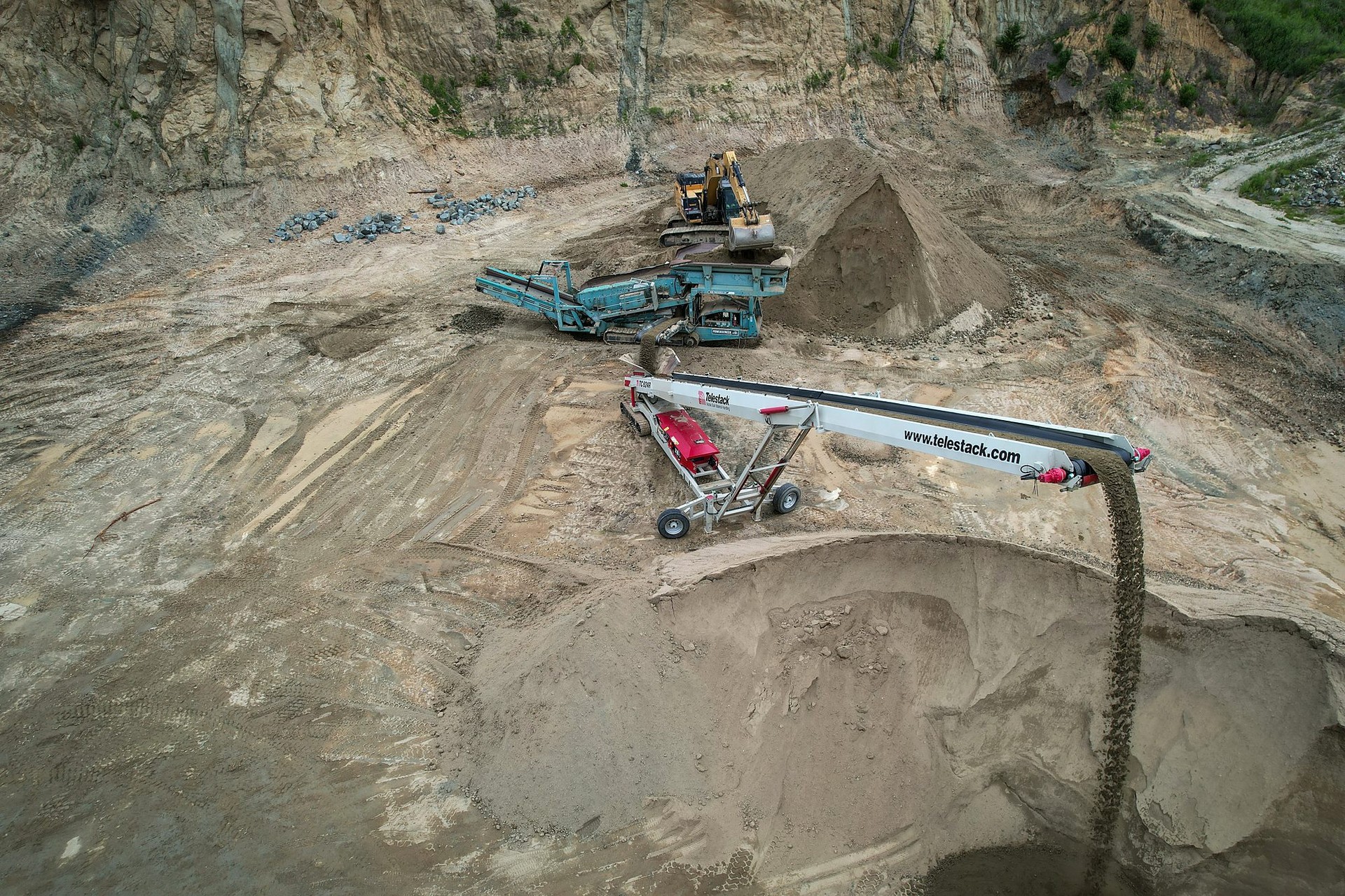 Conveyor dropping screened Sandrock onto a stockpile, seen from above