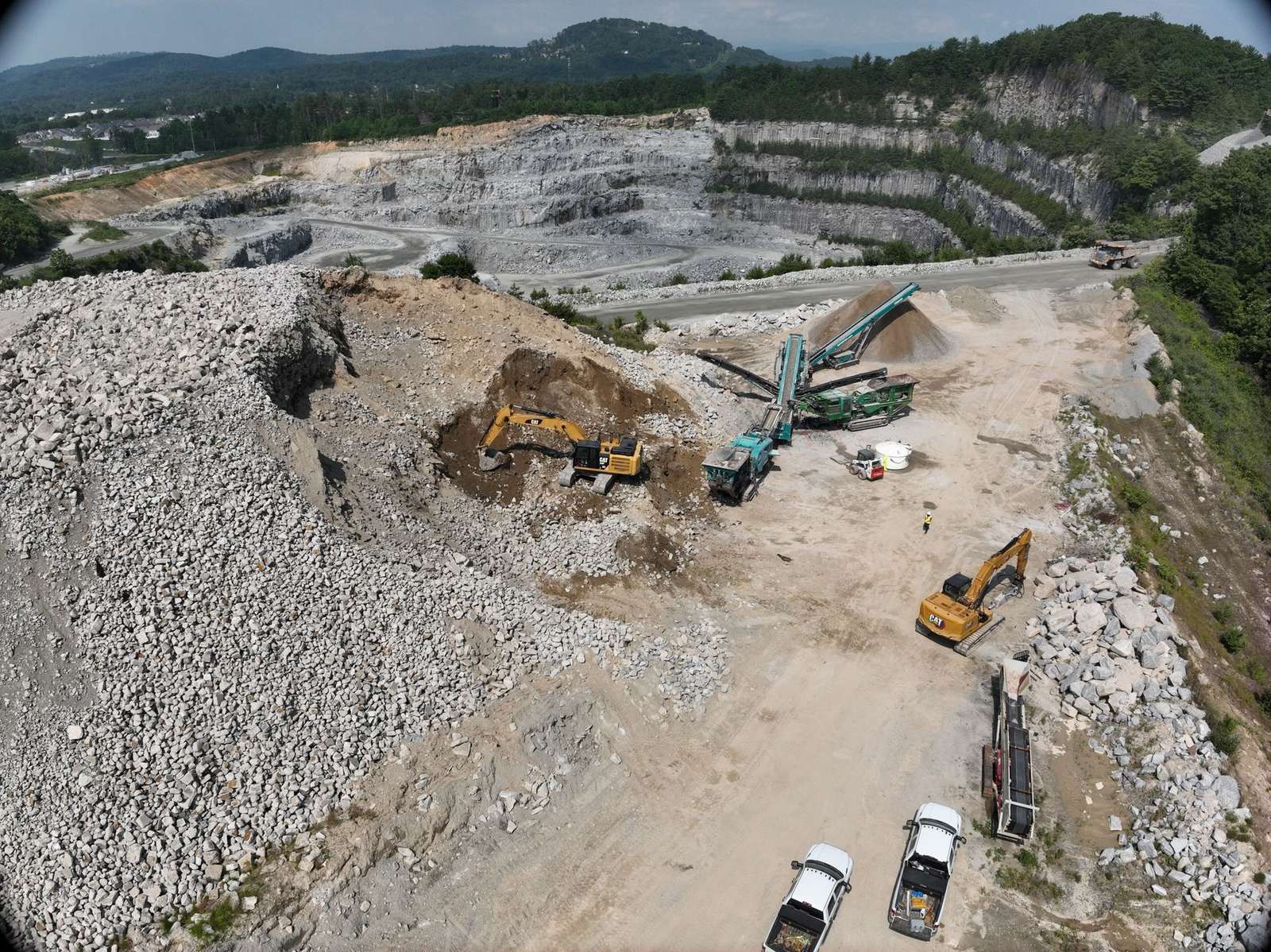 A-1 crushing and screening spread running at a quarry, with the mountains behind