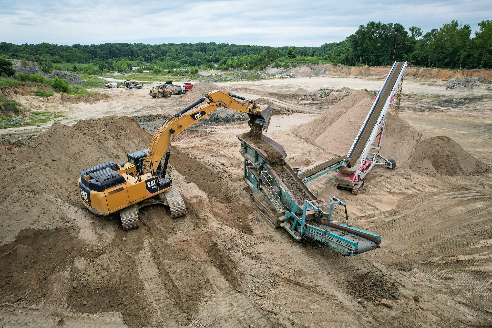 A-1 excavator feeding a screen while a conveyor stacks screened Sandrock