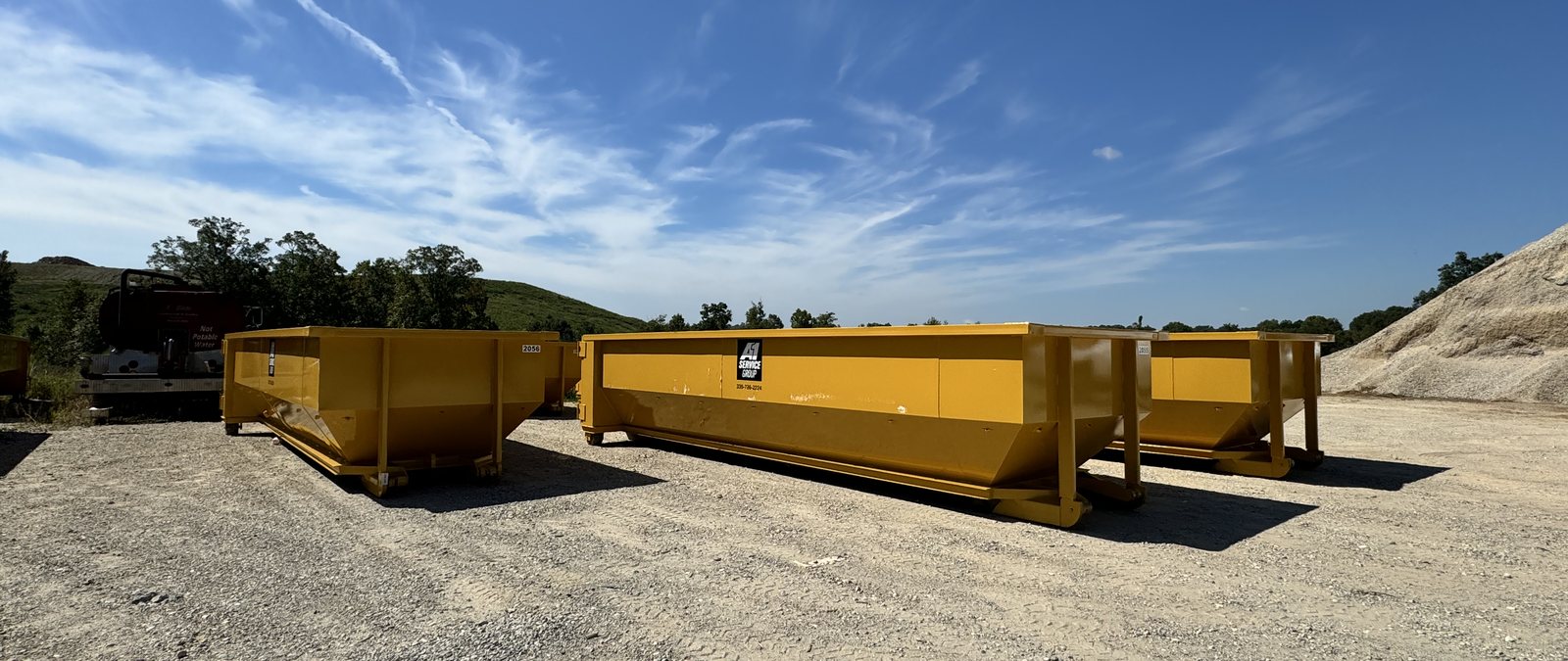 New yellow A-1 roll-off dumpsters staged at the A-1 yard in Greensboro, NC