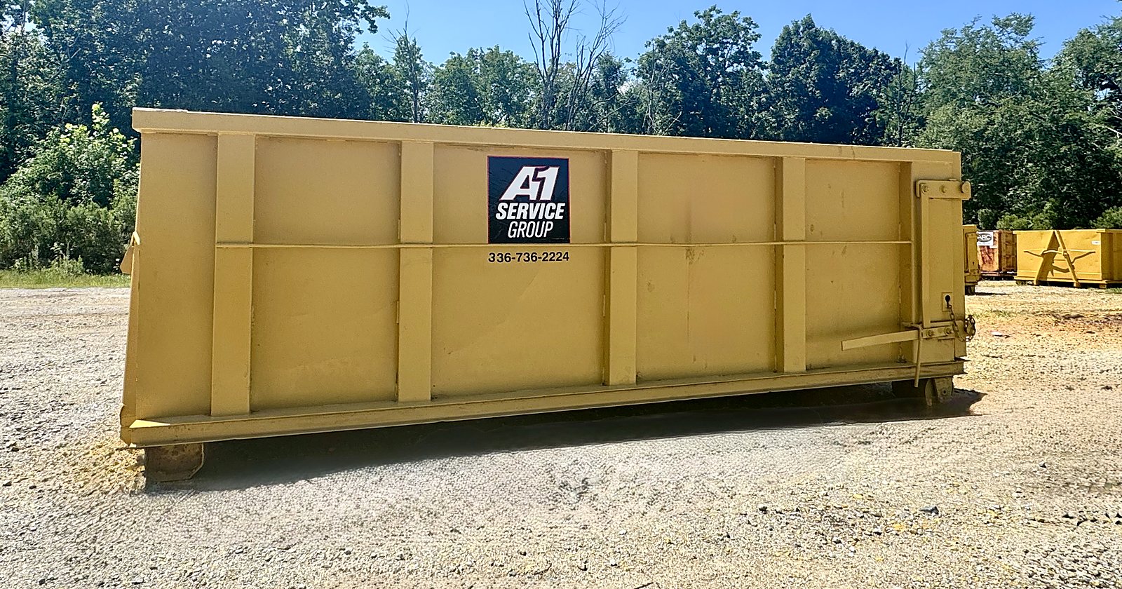 A yellow A-1 Service Group 15 yard roll-off dumpster