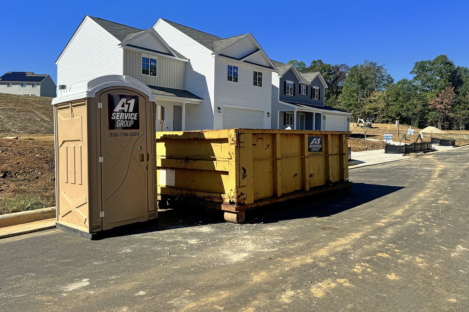 An A-1 portable toilet and roll-off dumpster in front of new homes in the Thornton community, Greensboro NC