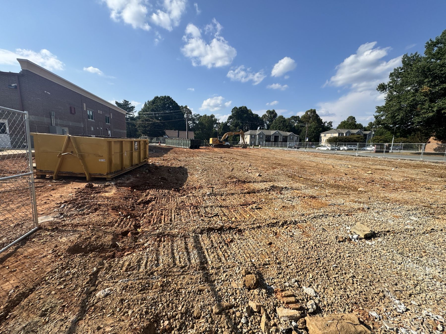 Cleared and graded demolition site with an A-1 roll-off dumpster