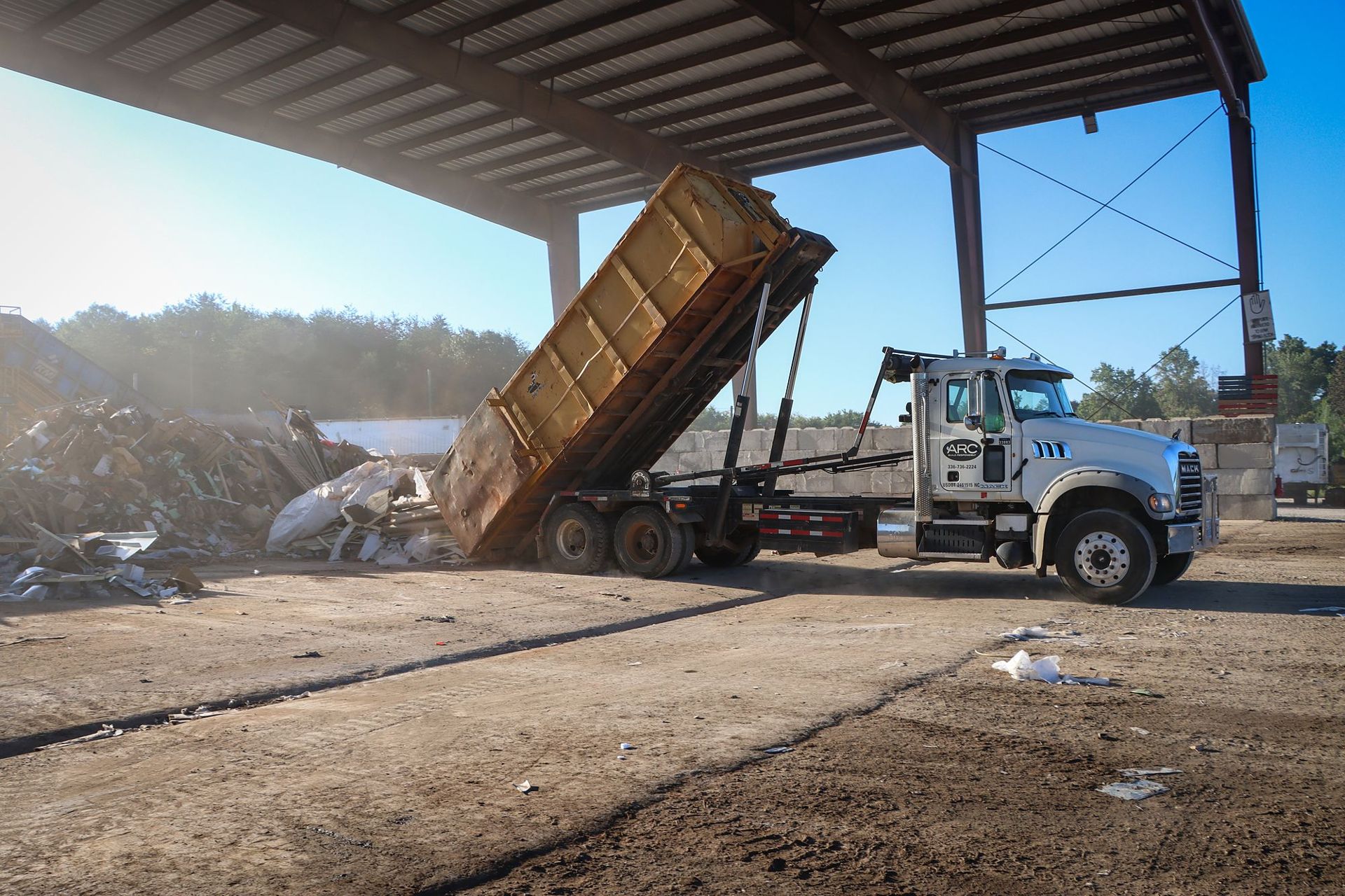 A-1 roll-off truck tipping a load under the roof at Abbey Green Transfer Station